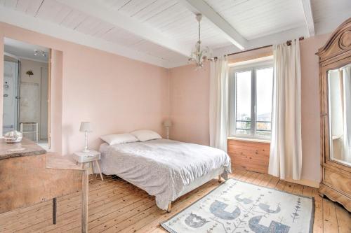 une chambre avec un lit et une grande fenêtre dans l'établissement La Esnaudière - Maison à moins d’un km du Rance, à Langrolay