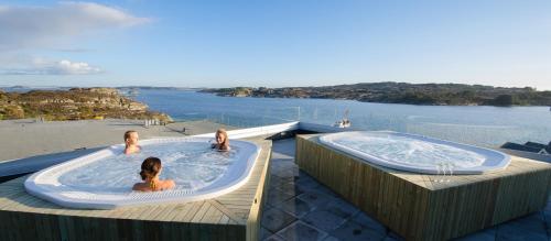 two girls sitting in a hot tub on a deck at Panorama Hotell & Resort in Steinsland