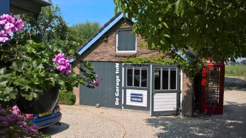 a garage with a door and a window at Holiday cottage de Garage Inn in Hank