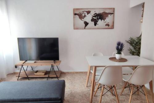 a living room with a table and a television at Apartamento en el centro de Elche con terraza in Elche