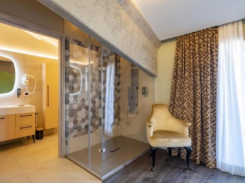 uma casa de banho com um chuveiro com uma cadeira e um lavatório em Villa Etru - Volterra, Tuscany em Peccioli