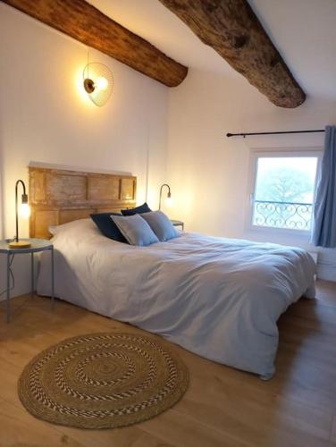 une chambre avec un grand lit et une fenêtre dans l'établissement Mas dans la garrigue, piscine, pétanque, ping pong, volley ball, à Saint-Paul-et-Valmalle