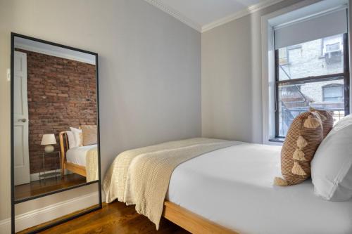 a bedroom with a large bed and a window at Blueground Soho wd nr shops groceries NYC-1430 in New York