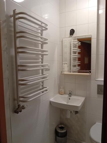 a white bathroom with a sink and a mirror at Hotel Górsko in Wieliczka