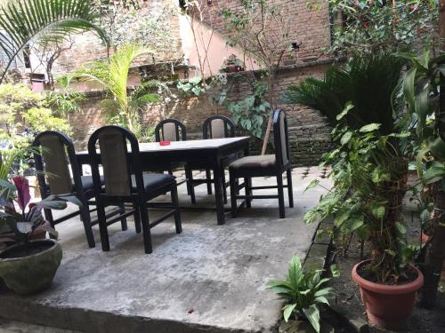 a table and chairs in a garden with plants at Hotel Serenity in Kathmandu