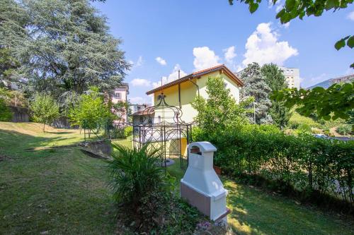 uma casa amarela com uma cerca num quintal em Franklin House - Happy Rentals em Lugano