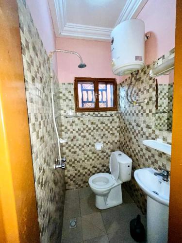 a bathroom with a toilet and a sink at Burkina meublé in Ouagadougou