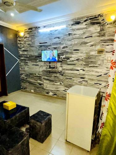 a room with a stone wall with a tv on it at Burkina meublé in Ouagadougou