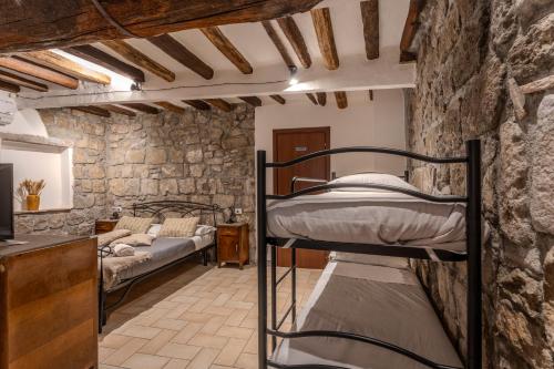 a room with two bunk beds in a stone wall at IL RICHIASTRO MEDIEVALE in Viterbo