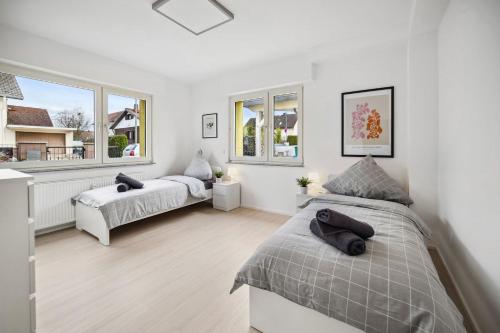 - 2 lits dans une chambre avec 2 fenêtres dans l'établissement Nice Apartments in Hanau, à Hanau