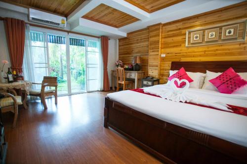 1 dormitorio con 1 cama grande con almohadas rojas y blancas en Maekhong Delta Boutique Hotel, en Mae Sai