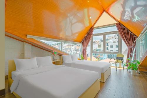 1 dormitorio con 2 camas y ventana grande en Nắng Chiều Central Hotel en Dalat