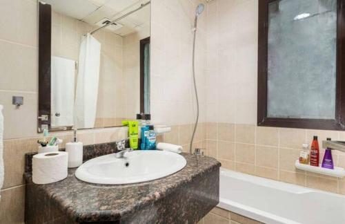 a bathroom with a sink and a bath tub at Manzil - Studio Apartment in Dubai Silicon Oasis near Dubai Outlet Mall in Dubai