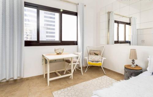 a white bedroom with a table and a chair at Manzil - Studio Apartment in Dubai Silicon Oasis near Dubai Outlet Mall in Dubai