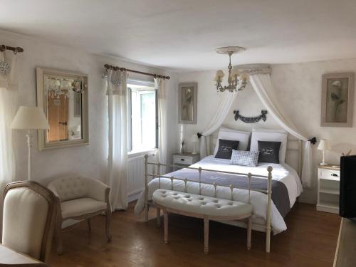 La Grange d'Hélène في شوليه: غرفة نوم بسرير كبير وكرسي