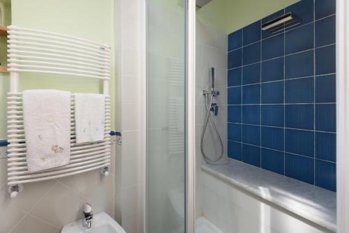 La salle de bains est pourvue d'une douche, de toilettes et de carrelage bleu. dans l'établissement Casa Mia A Cortona, à Cortone