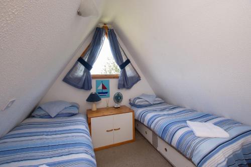 two twin beds in a room with a window at Chalet 106 in Deal