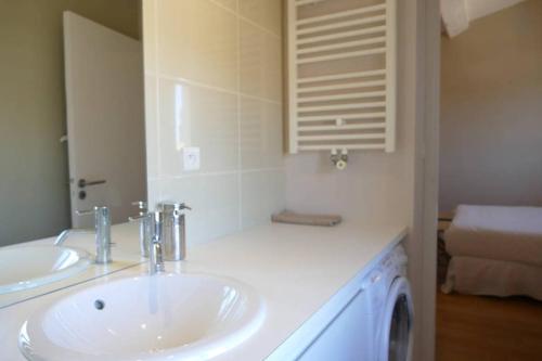 La salle de bains blanche est pourvue d'un lavabo et d'un miroir. dans l'établissement Appartement T2 de Luxe face au Jardin Public, à Bordeaux