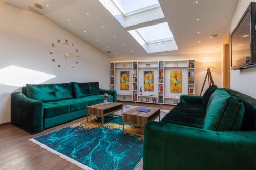 a living room with green furniture and a skylight at Old City Apartmani Sarajevo in Sarajevo