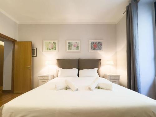 una camera da letto con un grande letto bianco con due cuscini di Maison Vittorio Borgo Pio a Roma