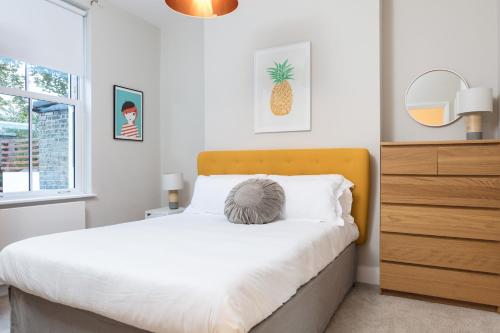 - une chambre avec un lit et une commode avec un ananas dans l'établissement Madison Hill - Byrne Garden 1 - Two bedroom home, à Londres