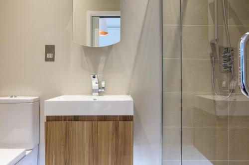 La salle de bains est pourvue d'un lavabo et d'une douche. dans l'établissement Madison Hill - Byrne Garden 1 - Two bedroom home, à Londres