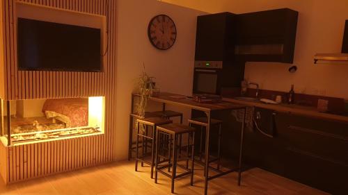 Eine Küche mit Kamin, Bar und Barhockern in der Unterkunft Love Room- Spa- Escale Amoureuse in Puygaillard-de-Quercy