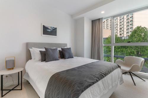 Un dormitorio blanco con una cama grande y una ventana. en Modern Apartment & Parking - Central & Quite, en Auckland