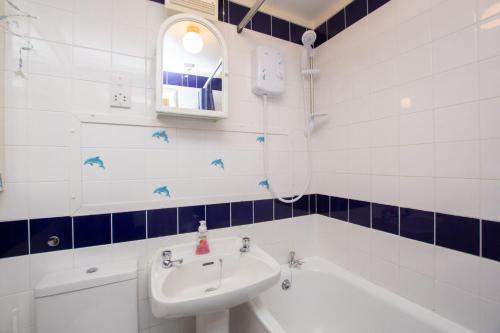 a bathroom with a sink and a bath tub at Chalet 134 in Deal