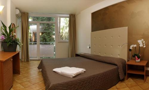 1 dormitorio con 1 cama con 2 toallas en Front Lake 2 Bardolino en Bardolino