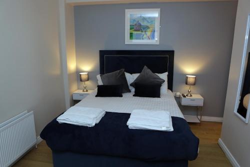 a bedroom with a large bed with two pillows at Causeway B&B in Bushmills