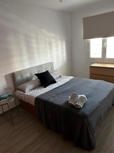 Un dormitorio con una cama grande con dos zapatos. en Apartment Foix, en Cubelles