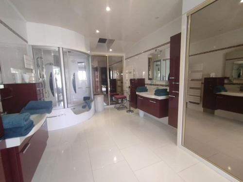 - une grande salle de bains avec deux lavabos et un grand miroir dans l'établissement Villa 5, El Pueblo au village naturiste, au Cap d'Agde