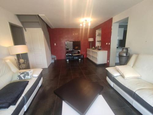 - un salon avec deux canapés blancs et une table dans l'établissement Villa 5, El Pueblo au village naturiste, au Cap d'Agde
