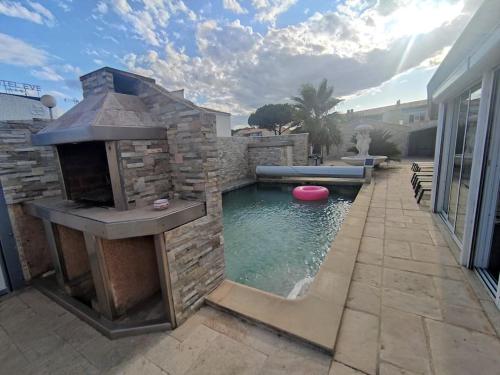 une arrière-cour avec une piscine avec un grill et un frisbee dans l'établissement Villa 5, El Pueblo au village naturiste, au Cap d'Agde