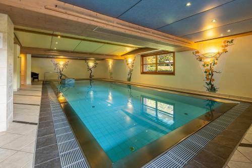 ein großer Pool in einem Haus in der Unterkunft IFA Alpenhof Wildental Hotel Kleinwalsertal Adults only in Mittelberg