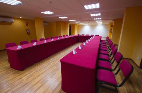 a conference room with pink tables and chairs at Xima Exclusive Cusco in Cusco