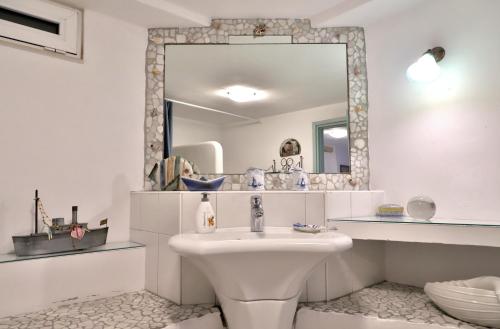 a white bathroom with a sink and a mirror at Olive House Traditional Villa with Pool in Sitia