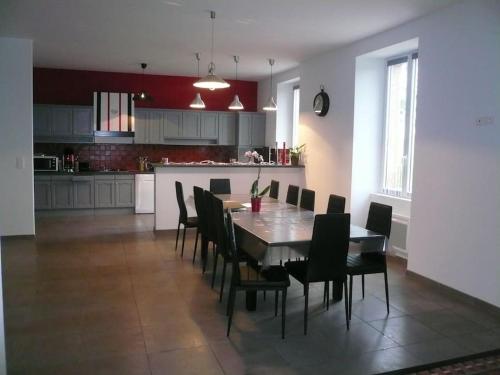 a kitchen and dining room with a table and chairs at Gîte le chant des tournesols piscine chauffée in Montirat