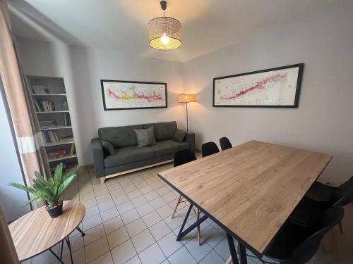 a living room with a table and a couch at Le Havre Citadin - Maison de ville à Poitiers in Poitiers