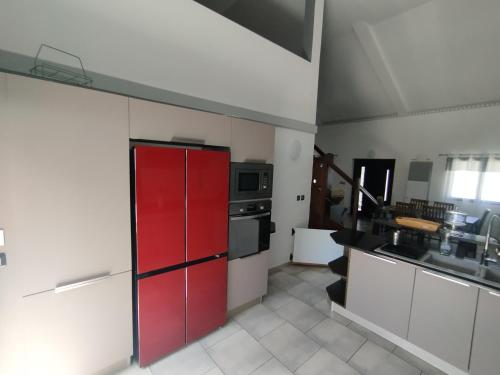 a kitchen with red cabinets and a red refrigerator at Chez Fred Saint André in Saint-André