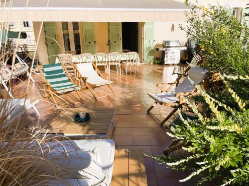 een patio met stoelen en tafels en een fornuis bij Maison Trenca in Menton