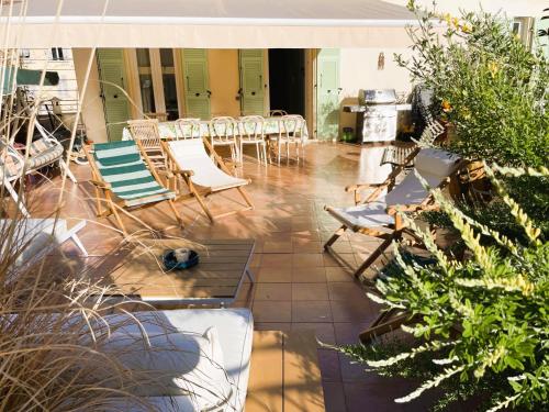 une terrasse avec des chaises, des tables et une cuisinière dans l'établissement Maison Trenca, à Menton