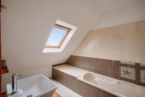 een badkamer met een wastafel en een bad bij Parenthese detente avec piscine in Plobannalec-Lesconil