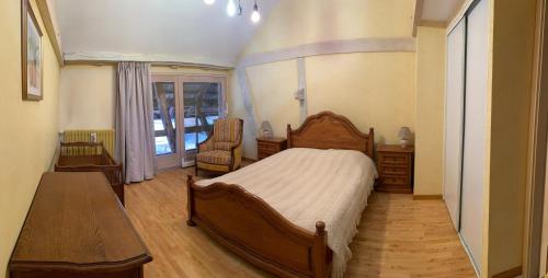 Schlafzimmer mit einem Holzbett und einem Tisch in der Unterkunft Ferme alsacienne in Soppe-le-Haut