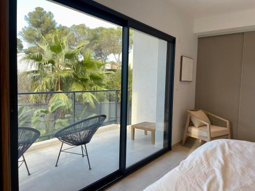 um quarto com vista para uma varanda com uma cama e cadeiras em Villa 443 em Saint-Raphaël