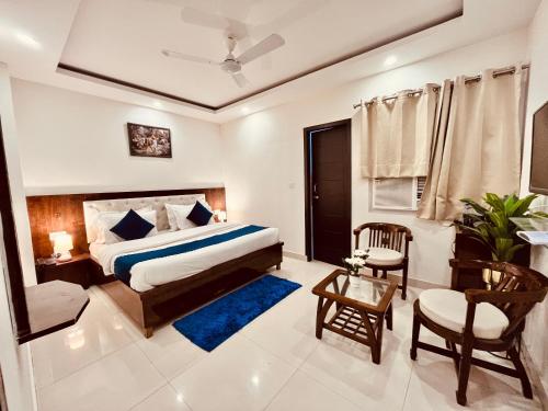 una camera con letto, sedia e tavolo di The Pacific Grand Haridwar a Haridwār