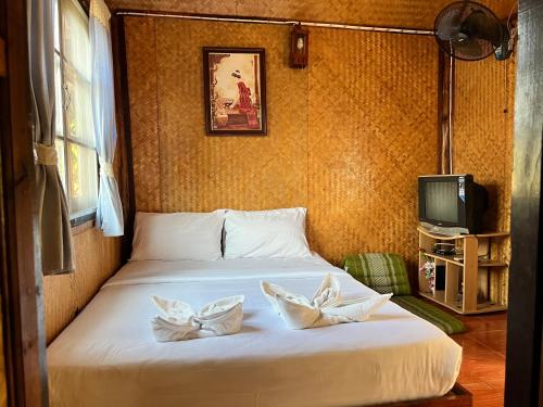 - une chambre avec un lit et 2 oreillers dans l'établissement Baan rabiang Pai บ้านระเบียงปาย, à Pai