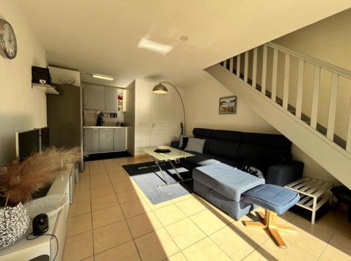 una sala de estar con un sofá y una escalera en Hag, en Valras-Plage