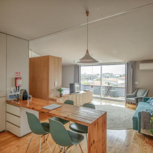 eine Küche und ein Wohnzimmer mit einem Tisch und Stühlen in der Unterkunft Baumhaus Serviced Living - Art & Design Apartments in Porto